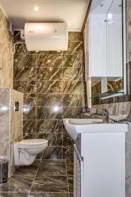 a bathroom with a sink and a toilet and a mirror at Apartcomplex Golden Bay in Ravda