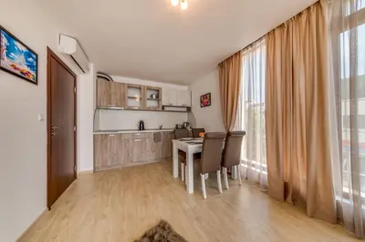 a kitchen and dining room with a table and chairs at Apartcomplex Golden Bay in Ravda