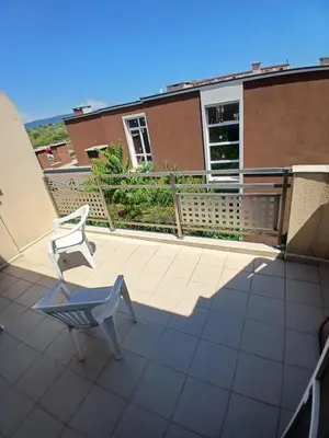 a white chair on a balcony with a building at Levante apartments in Nesebar