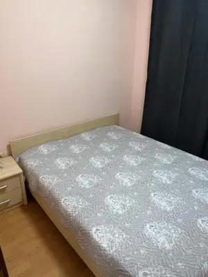 a small bedroom with a bed with a gray comforter at Частен апартамент Лагуна - Private Two-Bedroom Apartment Laguna in Primorsko