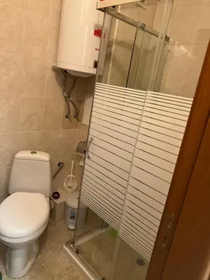 a bathroom with a toilet and a glass shower stall at Частен апартамент Лагуна - Private Two-Bedroom Apartment Laguna in Primorsko