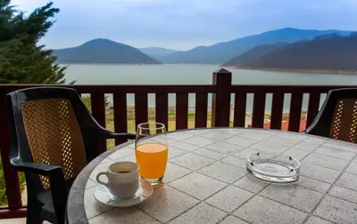 a table with a cup of coffee and a glass of orange juice at Holiday Home Paulovnia in Tschenge