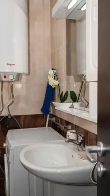 a bathroom with a sink and a toilet and a mirror at Lora boutique in Pomorie