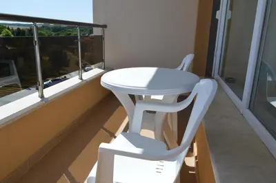 a white table and a chair in a room with a window at SummerHouse Lozenets in Lozenets
