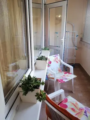 a balcony with two chairs and a table with plants at Apartament ,,EDELVAIS- LUX'' in Nesebar