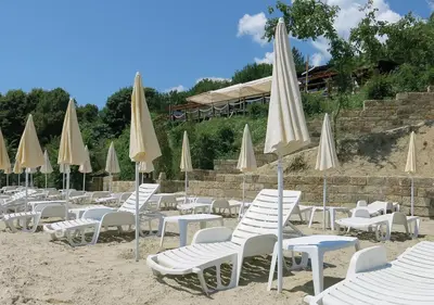a bunch of chairs and umbrellas on a beach at Family Hotel Albizia Beach in Varna City