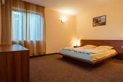a bedroom with a bed and a large window at Hotel Orchidea in Sozopol