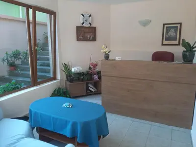 a living room with a blue table in a room at Hotel Orchidea in Sozopol