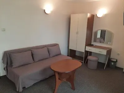 a living room with a couch and a table and a mirror at Hotel Orchidea in Sozopol