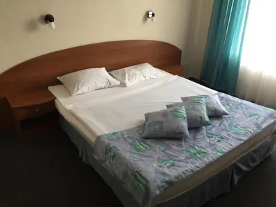 a bed with two pillows on it in a bedroom at Family Hotel Lazuren Briag in Burgas City