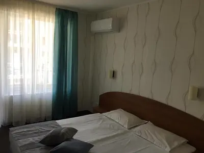 a bed in a bedroom with a window and a pillow at Family Hotel Lazuren Briag in Burgas City