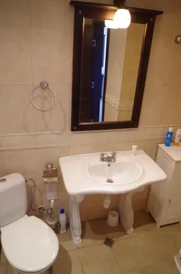 a bathroom with a sink and a toilet and a mirror at Beautiful 1st-Line Seaview Private Appartement in The Cliff resort in Obzor
