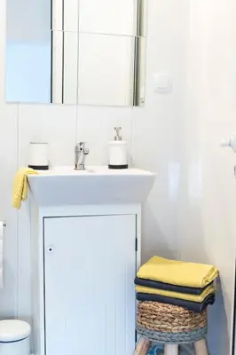a bathroom with a sink and a stool under a sink at Balabanov White in Varna City