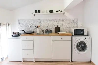 a kitchen with a washing machine and a microwave at Balabanov White in Varna City
