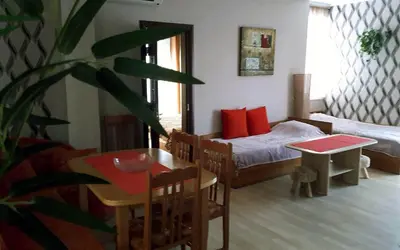 a living room with a bed and a table and a table sidx sidx at Apartment Larissa in Pomorie