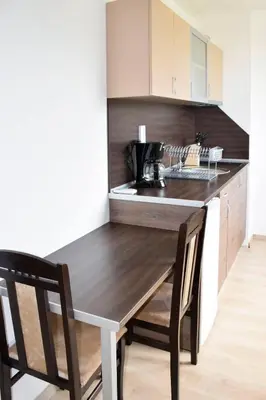 a kitchen with a wooden table and two chairs at studio ASI in Obzor