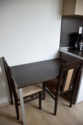 a wooden table and two chairs next to a kitchen at studio ASI in Obzor
