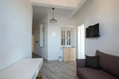 a room with a bed and a couch and a tv at Hostel Musala in Varna City