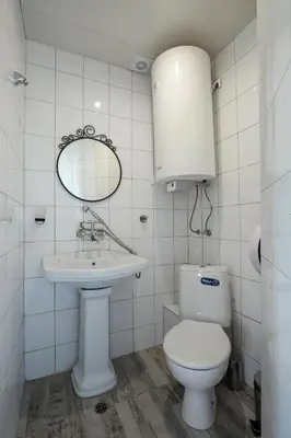 a bathroom with a toilet and a sink and a mirror at Hostel Musala in Varna City