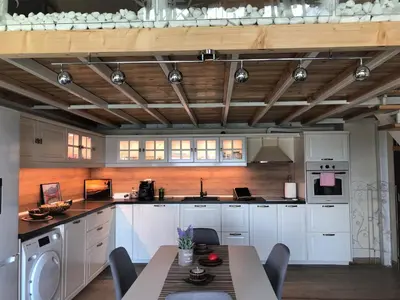 a kitchen with white cabinets and a table with chairs at Villa Victoria - a luxury appartment with icredible Seaview in Sozopol