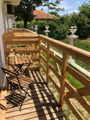 a wooden deck with two chairs and a table at Villa Adrian in Shkorpilovtsi