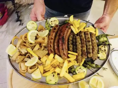 a plate of food with sausages and other foods at Villa Adrian in Shkorpilovtsi