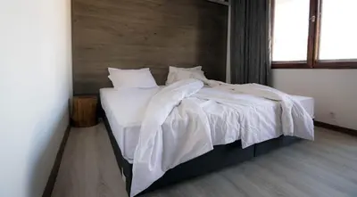 a bedroom with a bed with white sheets and pillows at Cherry Garden Apartments in Sveti Vlas