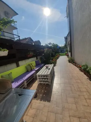 a patio with purple and green benches on a building at Cherry Garden Apartments in Sveti Vlas