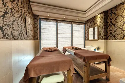 two beds in a room with a window at Penelopa Palace Apart Hotel & SPA in Pomorie