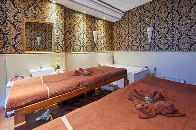 a bedroom with two beds and a mirror on the wall at Penelopa Palace Apart Hotel & SPA in Pomorie