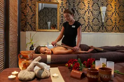 a woman laying on a bed in a room at Penelopa Palace Apart Hotel & SPA in Pomorie
