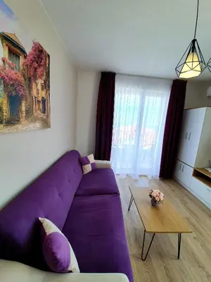 a living room with a purple couch and a table at Old Sailor Apartment in Obzor