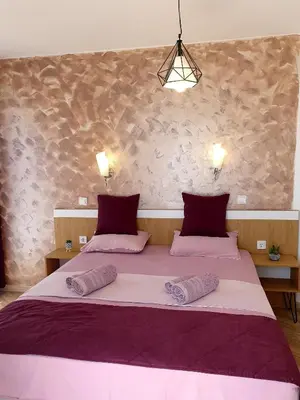 a bedroom with a large bed with two pillows at Old Sailor Apartment in Obzor