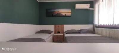 two beds in a room with green walls at Семейна къща “Вълчеви” in Kiten
