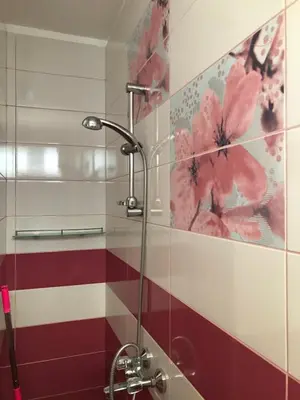 a shower stall in a bathroom with flowers on the wall at Семейна къща “Вълчеви” in Kiten