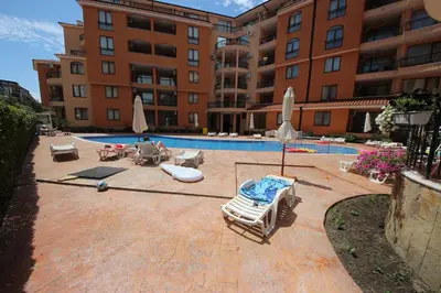 a swimming pool with lounge chairs and umbrellas in front of a building at Efir 2 - Menada Apartments in Sunny Beach