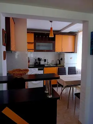 a kitchen with orange cabinets and tables and chairs at Laura in Primorsko