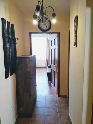 a hallway with a clock on the wall and a door at Laura in Primorsko