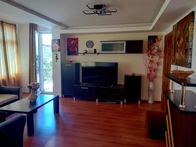 a living room with a flat screen tv and a table at Laura in Primorsko
