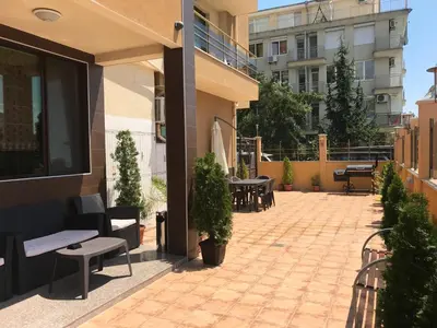 a patio with chairs and tables on a building at Golden Sun in Pomorie