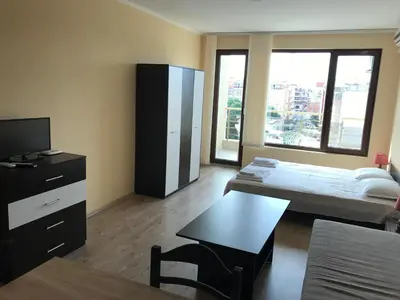 a room with a bed and a table and a tv at Golden Sun in Pomorie