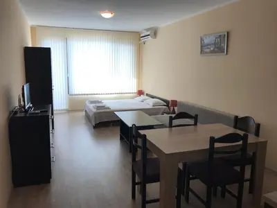 a room with a table and a bed and a dining room at Golden Sun in Pomorie