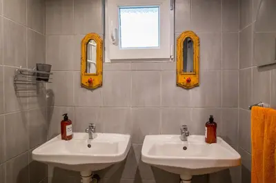 a bathroom with two sinks and two mirrors at Nomado Hostel in Varna City