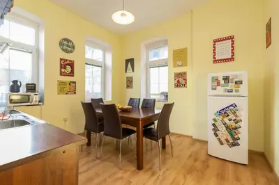 a kitchen and dining room with a table and a refrigerator at Nomado Hostel in Varna City