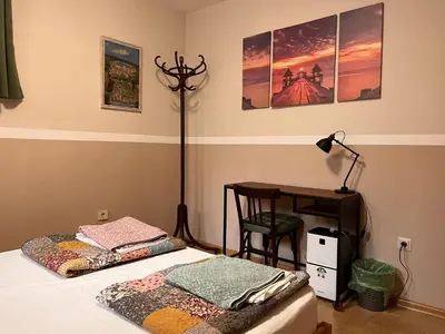 a bedroom with a bed and a desk and a lamp at Nomado Hostel in Varna City