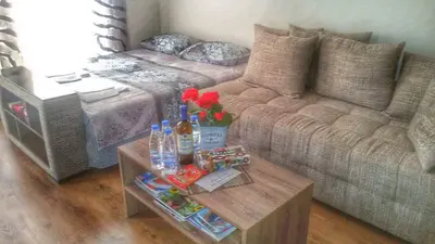 a living room with a couch and a coffee table at DIAMOND APARTMENT №1 - RELAX HOLIDAY VIEWS SEA AND POOL in Burgas City
