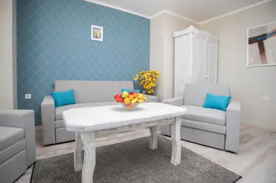 a living room with a table with a bowl of fruit on it at Oasis Del Sol - Front Beach in Lozenets