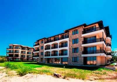 an apartment building on the beach next to the sand at Oasis Del Sol - Front Beach in Lozenets