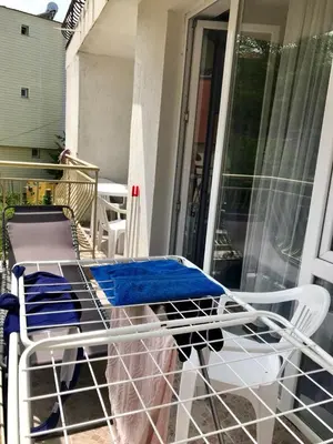 a chair sitting on a porch next to a glass door at Alice Apartment in Obzor