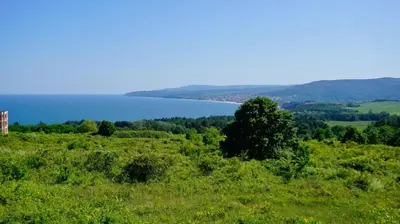 a view of a field with a lake in the background at Апартаменти Сънбрийз - Sunbreeze Apartments in Byala